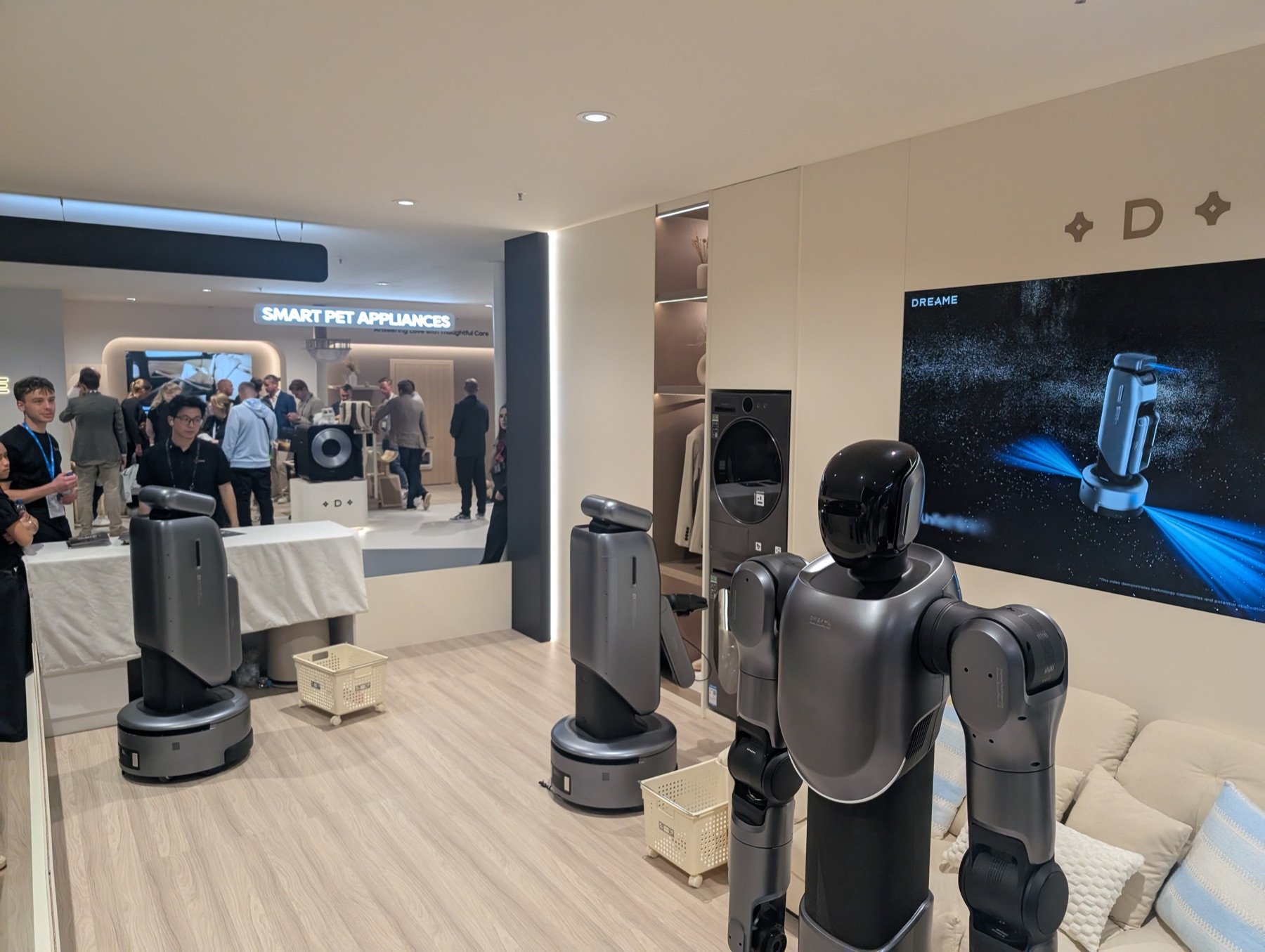 Das Wohnzimmer am Stand von Dreame mit Humanoid, zwei Saugrobotern und Wäschekörben